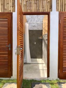 an open door to a shower with a curtain at NOMAD Tropical Hostel Canggu in Dalung