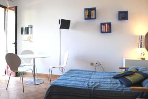 una camera da letto con un letto, un tavolo e delle sedie di Blulatte a Valledoria Altre 37 foto