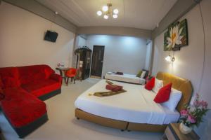 sypialnia z łóżkiem i czerwoną kanapą w obiekcie Casa Krung Kao w mieście Phra Nakhon Si Ayutthaya