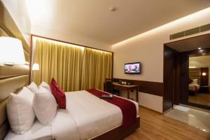 a hotel room with a bed and a television at Ayra Boutique Hotel in Bangalore