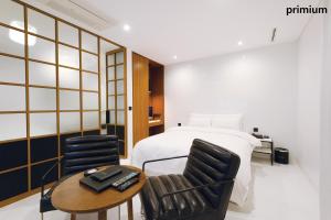une chambre avec un lit, deux chaises et une table dans l'établissement Hotel The Artist Yeoksam, à Séoul