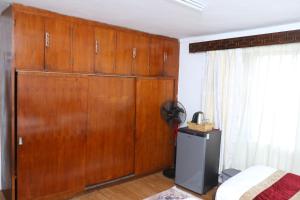 een kamer met een grote houten kast en een bed bij Himalaya Inn in Kathmandu