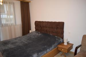 een slaapkamer met een bed, een stoel en een raam bij Супер луксозен апартамент в Winslow in Bansko