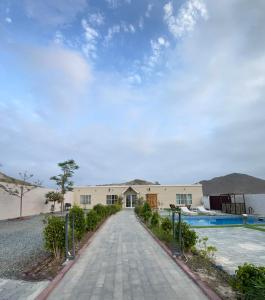 a driveway leading to a building with a pool at 800 Mountain Resort Vacation House in Fujairah