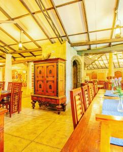 a room with a wooden cabinet and tables and chairs at Hotel Ranthil in Galle