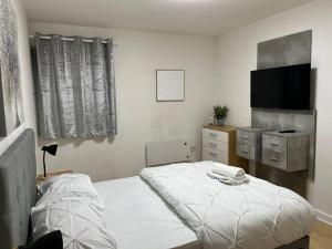 a bedroom with a bed and a flat screen tv at Cosy & sweet, 1bd Spacious By Media City in Manchester