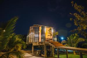 a glass house on the beach at night at STAY PILAFarm in Ban Nam Chun Yai