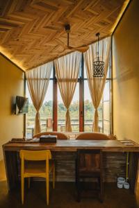 ein Schlafzimmer mit einem Schreibtisch und einem großen Fenster in der Unterkunft STAY PILAFarm in Ban Nam Chun Yai