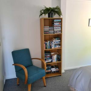 陶波的住宿－Wharewaka Haven，书架旁的蓝色椅子