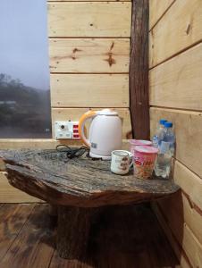 eine Theke mit einer Kaffeemaschine auf einem Holztisch in der Unterkunft Y Bé Homestay, Kon Vơng Kia, Măng Đen 