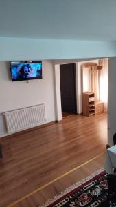 een woonkamer met een flatscreen-tv aan de muur bij Casa Dracea in Comarnic