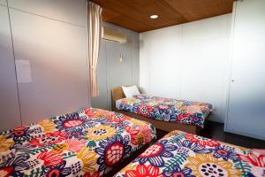 Postel nebo postele na pokoji v ubytování 修善寺フォーレスト 天然温泉が24時間楽しめキッチン電子レンジダイニングテーブル完備 + 37 fotografií