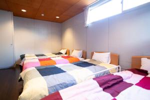 Postel nebo postele na pokoji v ubytování 修善寺フォーレスト 天然温泉が24時間楽しめキッチン電子レンジダイニングテーブル完備