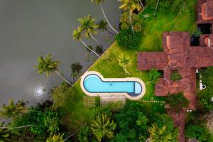 an aerial view of a house with a swimming pool at Cranganor History Café & Riverside Château in Parūr