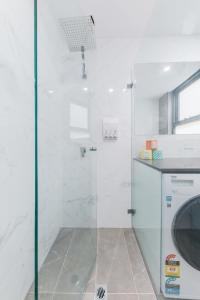 een douche met een glazen deur in de badkamer bij Grace at Mosman Apartments in Sydney