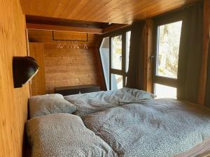 1 dormitorio con 1 cama en una habitación con ventana en Malcantone/Tessin, Bosco della Bella, Casetta 15, en Termine