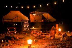 ein Zelt mit Kerzen und ein Schild in der Nacht in der Unterkunft ASOBI HACK 