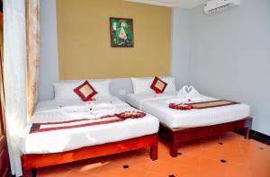 two beds in a room with red flowers on them at Thai Hoa Mui Ne Resort in Mui Ne