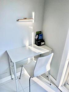 a white desk and a white chair in a room at A Mid Somerset Dream in West Kelowna