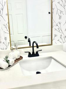 a bathroom with a sink and a mirror at A Mid Somerset Dream in West Kelowna