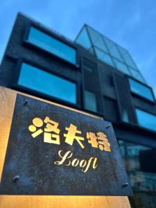 una señal frente a un edificio alto en 洛夫特Looft包棟民宿, en Hengchun