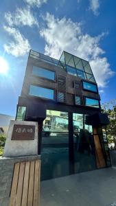 un edificio con finestre in vetro sul lato di 墾丁恆春包棟 l 洛夫特Looft民宿 a Città Vecchia di Hengchun
