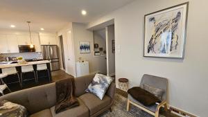 a living room with a couch and a kitchen at RB Homes in Ottawa