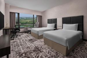 a hotel room with two beds and a desk at Crowne Plaza Shanghai Jinshan, an IHG Hotel in Jinshan