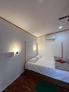 a bedroom with a white bed and a green rug at Mountain Palm patnem beach in Patnem