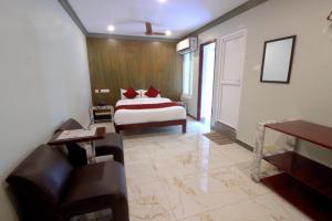 um quarto com uma cama e um sofá num quarto em Serenity Sands Beach Resort em Pondicherry