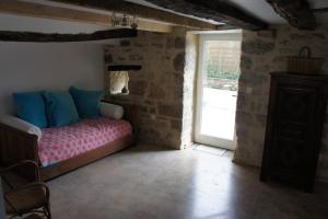 1 dormitorio con 1 cama en una habitación con ventana en Maison de village rénovée, en Meyronne