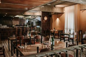 restauracja z drewnianymi stołami i krzesłami oraz kuchnią w obiekcie Hotel Mokozoyo w mieście George Town