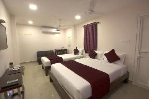 a hotel room with two beds and a television at Serenity Sands Beach Resort in Puducherry