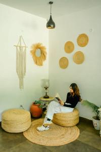 une femme assise sur une chaise circulaire dans une pièce dans l'établissement Locomo Boutique, Morjim - Stay Work Eat, à Morjim