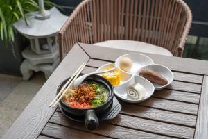 a bowl of food sitting on a table with chopsticks at Dali Luyu Cliff Seaview Inn in Dali