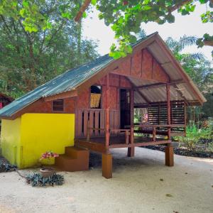 Casa de madera pequeña con porche y balcón en Sawasdee Resort, en Koh Chang