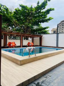 a swimming pool with two red chairs next to it at Sapphire Height Three Bedroom Apartment in Lagos