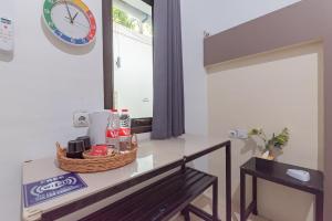a room with a table and a clock on the wall at RedDoorz @ Jalan Raya Tuparev Karawang in Karawang