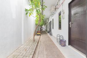 a narrow alley with a tree on the side of a building at RedDoorz @ Jalan Raya Tuparev Karawang in Karawang