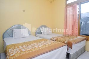 Ένα ή περισσότερα κρεβάτια σε δωμάτιο στο Hotel Sido Langgeng Tawangmangu Mitra RedDoorz