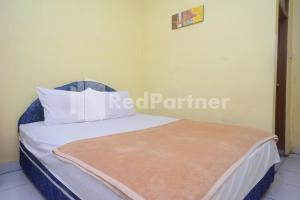 Ένα ή περισσότερα κρεβάτια σε δωμάτιο στο Hotel Sido Langgeng Tawangmangu Mitra RedDoorz