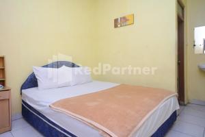 Ένα ή περισσότερα κρεβάτια σε δωμάτιο στο Hotel Sido Langgeng Tawangmangu Mitra RedDoorz