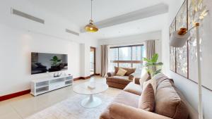 uma sala de estar com um sofá e uma mesa em Primestay - Golden Mile 2 1BR, Palm Jumeirah em Dubai