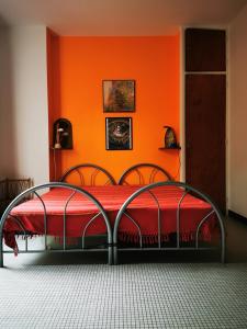 1 dormitorio con 1 cama con pared de color naranja en Large family house close to the beach en Les Mathes
