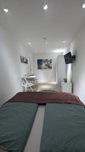 1 dormitorio con 1 cama, escritorio y nevera en Ferienwohnung an der Dhron, en Neumagen-Dhron