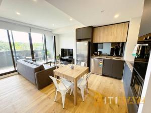 une cuisine et un salon avec une table et un canapé dans l'établissement Lavish in Lyneham - 2BD 1Bth Apt, à Canberra