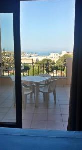 einen weißen Tisch und Stühle auf einem Balkon mit Aussicht in der Unterkunft Moresco Resort in Lampedusa