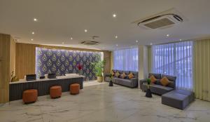 um átrio com sofás e uma secretária num edifício em Grand Continent Hebbal A Sarovar Portico Affiliate Hotel em Bangalore