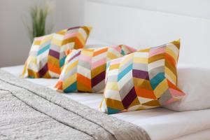 a group of pillows sitting on top of a bed at One-Bedroom Capital Apartment by Renters in Warsaw