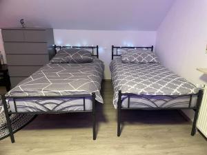 two beds sitting next to each other in a bedroom at Sky Studio Apartment 1,5 Zimmer für 4 Leute Zentral 35qm S-Bahn Mercedes Benz in Magstadt +56 photos